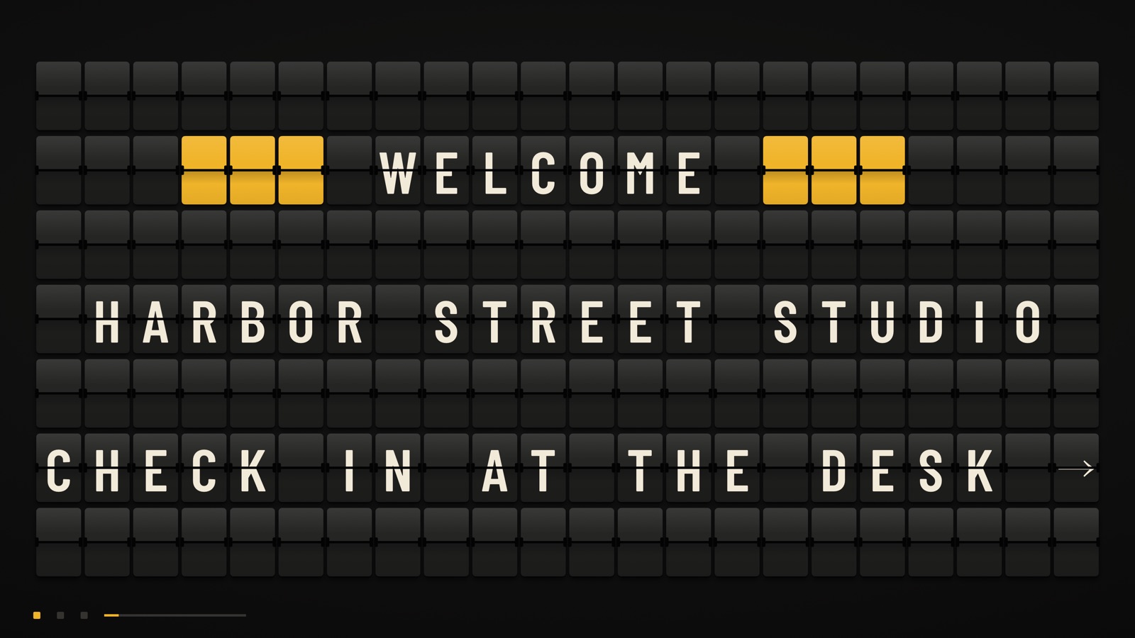A TV showing a split-flap board that reads Welcome, Harbor Street Studio, check in at the desk